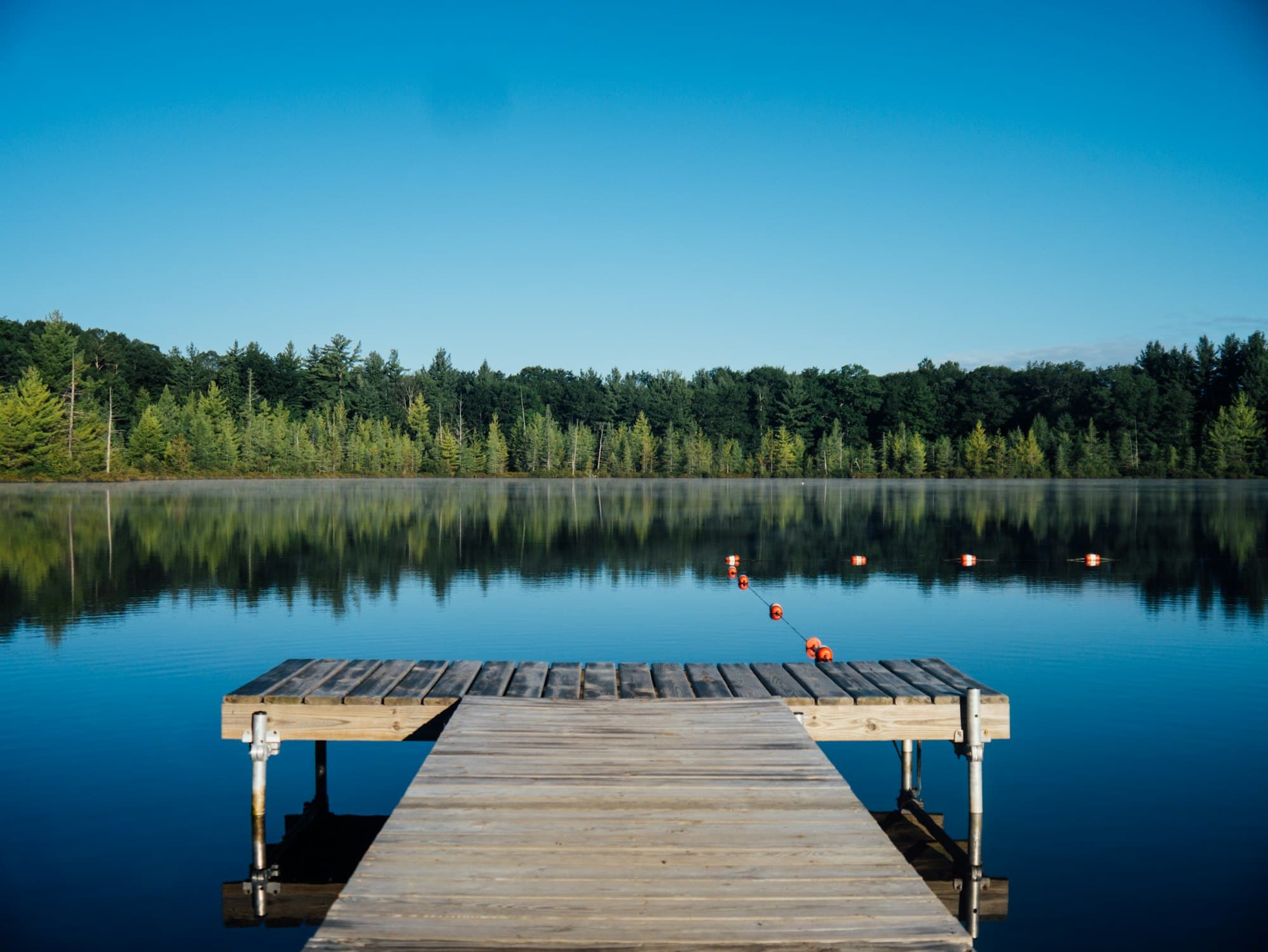 A wooden dock on a calm blue lake