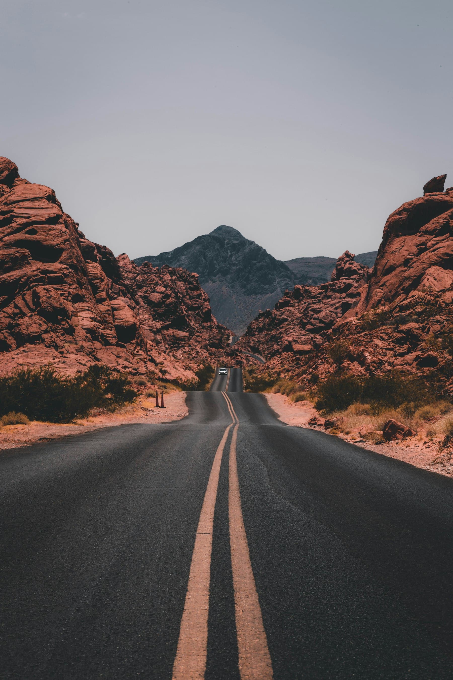 A desert highway running toward a rocky mountain